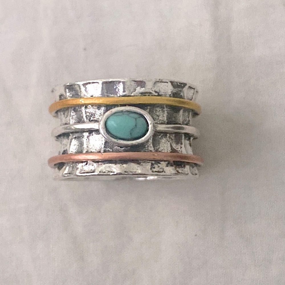 Beautiful, new, silver ring . Tourquise with a band of gold, silver and copper.